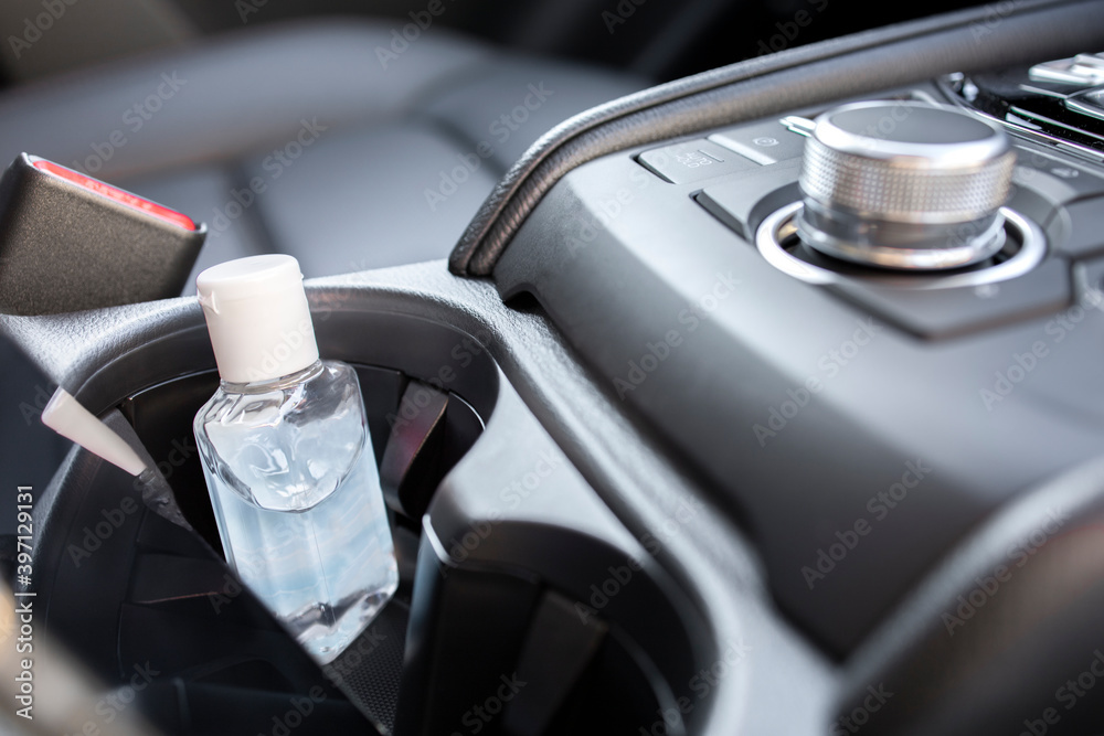 Closeup a small bottle of alcohol gel sanitizer in a car. Wash hand before driving in a new normal lifestyle to prevent, protect, and avoid a spread of coronavirus (covid-19) and any kinds of germs.