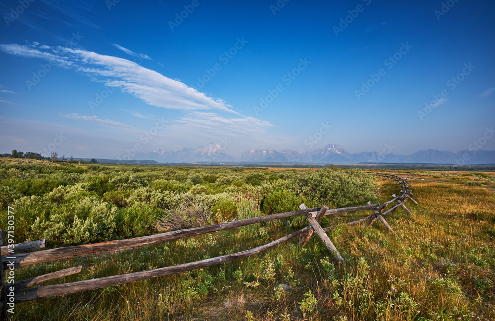 Fototapeta premium Old fashioned split rail wooden fence on the land of Cunningham Ranch, Moose, Wyoming. Teton mountains in the distance to the West