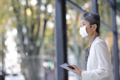マスクをつけたシニア世代の日本人ビジネスウーマン © arc image gallery