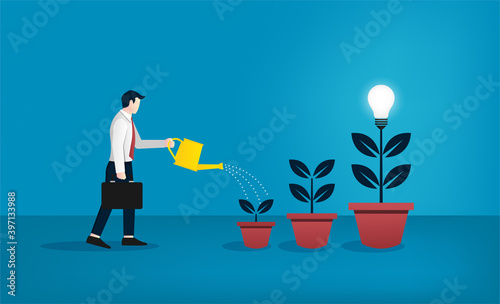 Businessman watering the trees of bulb concept. Growing new idea and creativity symbol