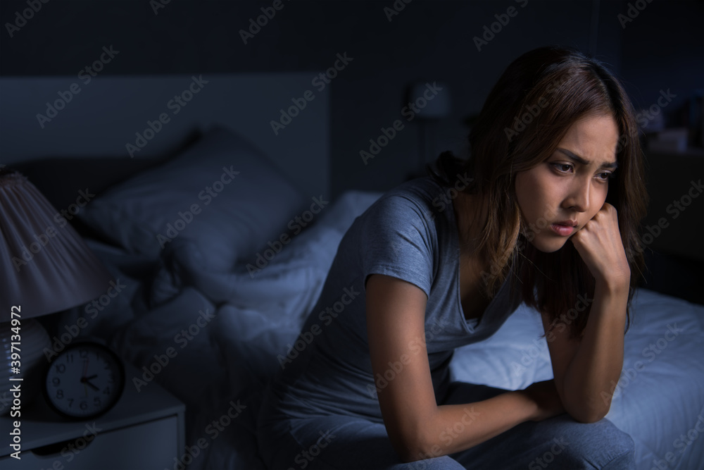 Depressed young Asian woman sitting in bed cannot sleep from insomnia.. Depressed young Asian woman sitting in bed cannot sleep from insomnia..