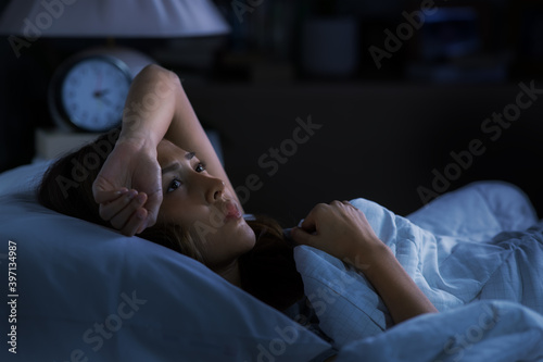 Fotografia Depressed young woman lying in bed cannot sleep from insomnia