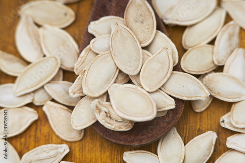 white pumpkin seeds on a wooden spoon