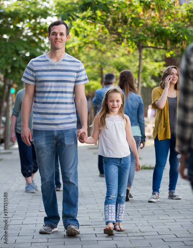 Cheerful father with little girl walking in the park