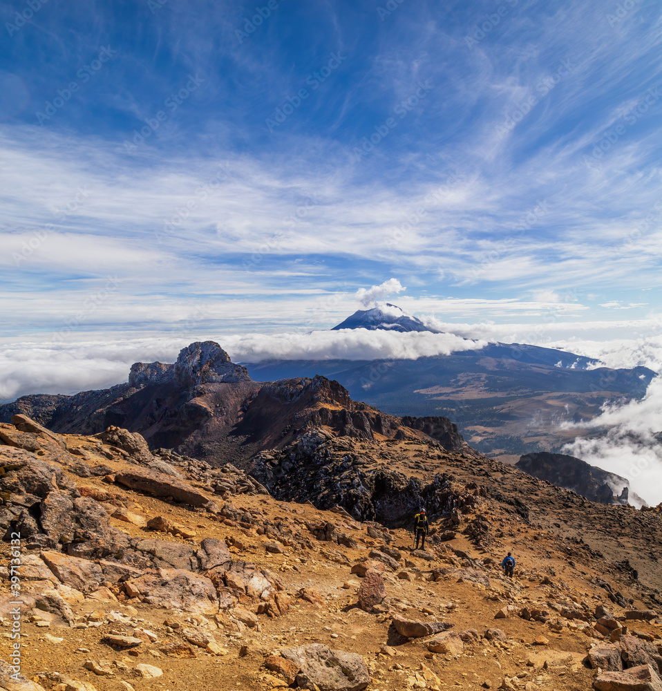 Naklejka premium Two hikers go hiking to the volcanoes. Climbing of mountain. Trekking in the iztaccihuatl volcano