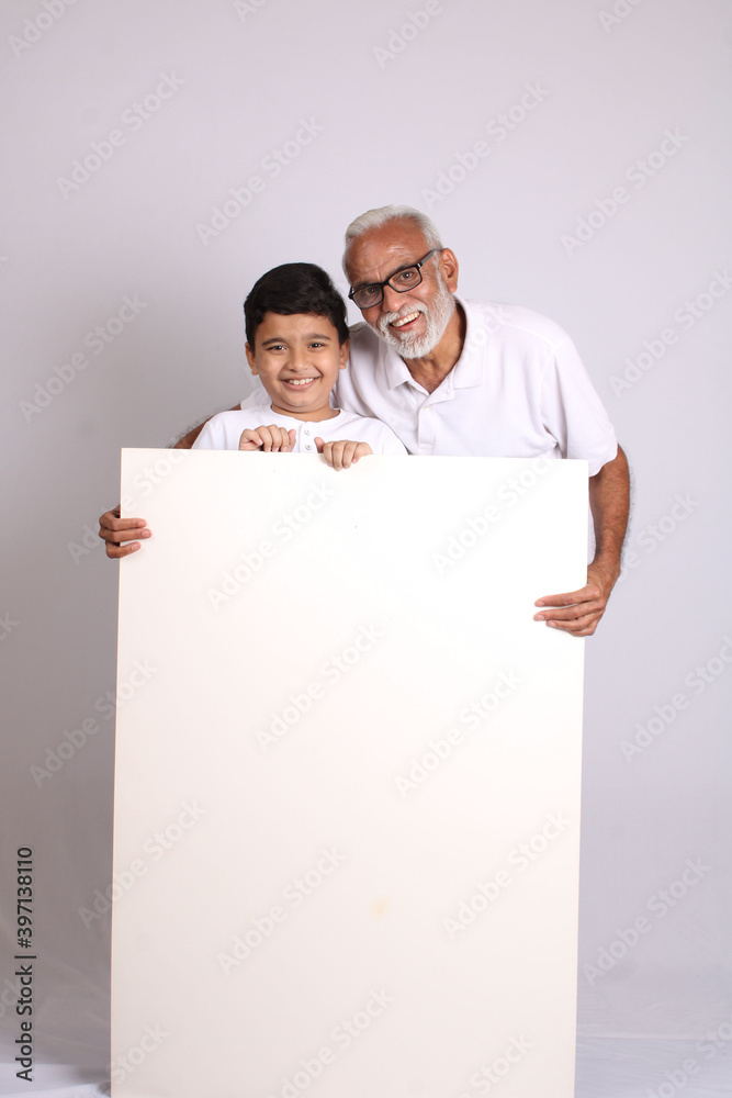 Young asian schoolboy with his grand father or senior man showing blank copy space.