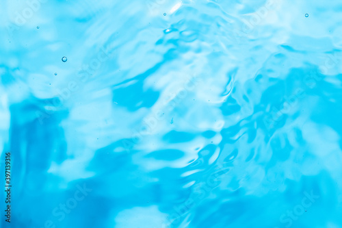 Фотография The blue water surface on the swaying shore produces bules.