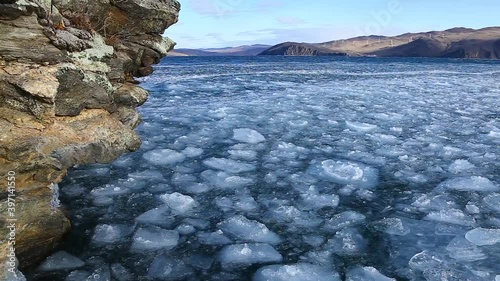 Floating ice in Baikal lake near the rocky shore at the time of freezing