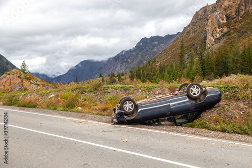 overturned car lies on the roof, broken bumper