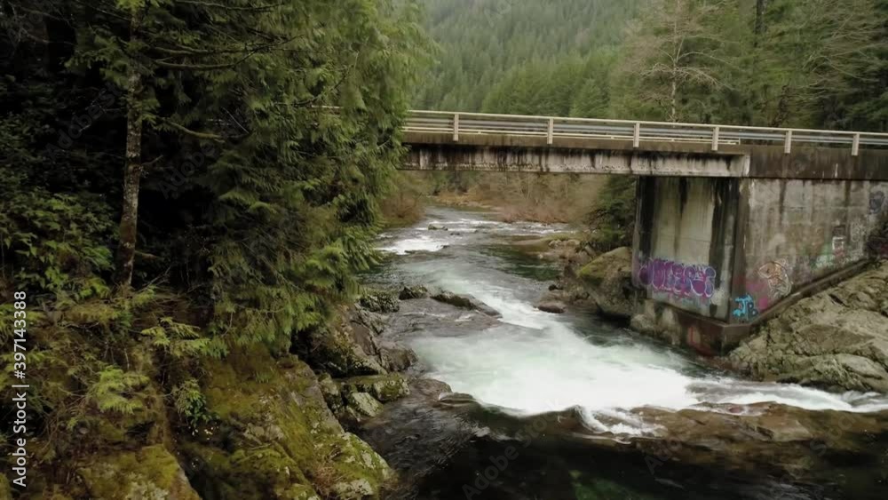 Bridge crosses Washougal River with graffiti on one side, aerial slow motion Bridge crosses Washougal River with graffiti on one side, aerial slow motion