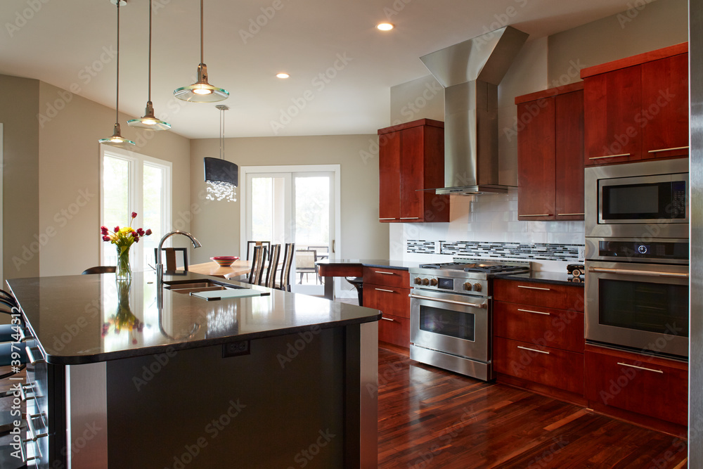 Fototapeta premium Interior of modern kitchen with red wood cabinets and floor with a large island