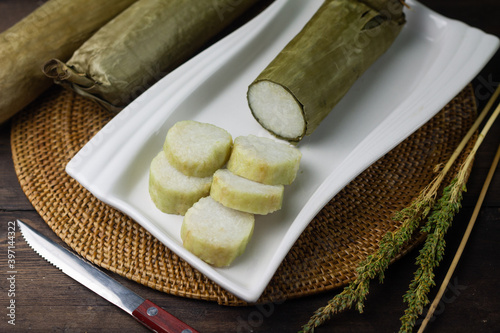 Lontong or boiled rice cake, Indonesian popular rice cake wrapped with banana leaves,  usually eat with chicken or beef satay. Served on ceramic white plate. 
 photo