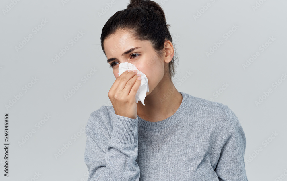 Woman holding napkin near face health problems runny nose flu Woman holding napkin near face health problems runny nose flu