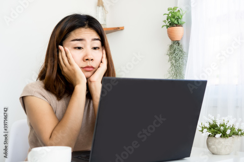 unmotivated Asian woman lazy to work quarantine at home office photo