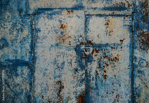 Old painted blue metal door with a padlock