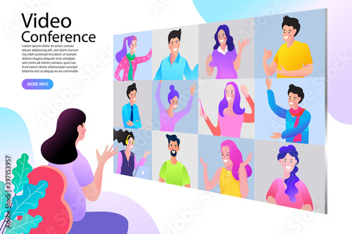 A woman attends a large video conference or webinar. The screen shows a grid view of many participants connecting remotely for an online meeting, representing virtual collaboration technology.