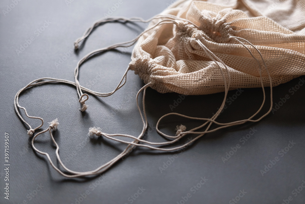Three reusable string bags for fruits, vegetables, grocery or other products on the grey background, closeup. Three reusable string bags for fruits, vegetables, grocery or other products on the grey background, closeup.