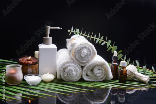 spa still life of,green eucalyptus , herbal ball and candles rolled towel ,oil bottle on green palm photo