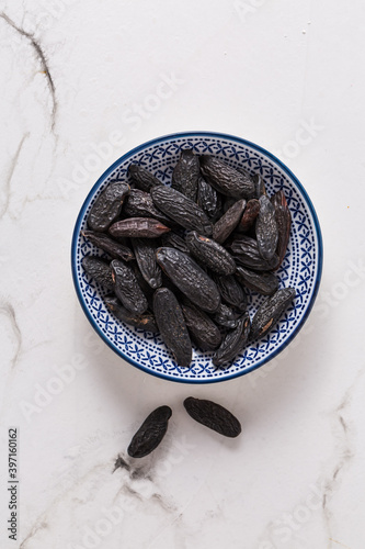 Fragrant tonka beans in small bowl on white background, baking flavored ingredient photo