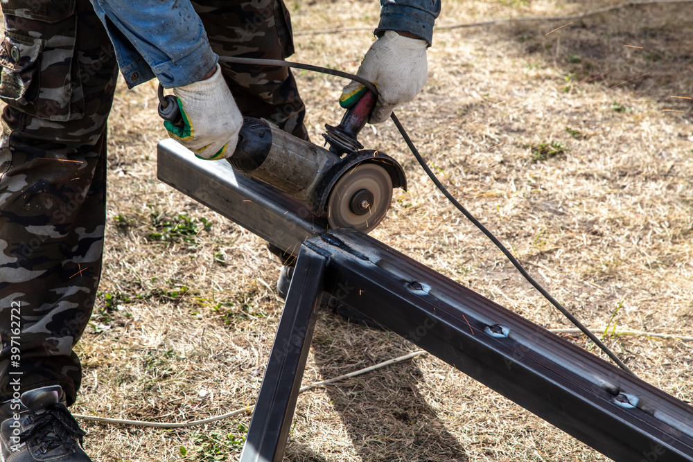 A worker cuts metal at a construction site. Technology