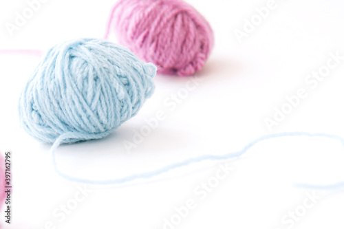 Two skeins of multi-colored woolen yarn on a light background with copy space