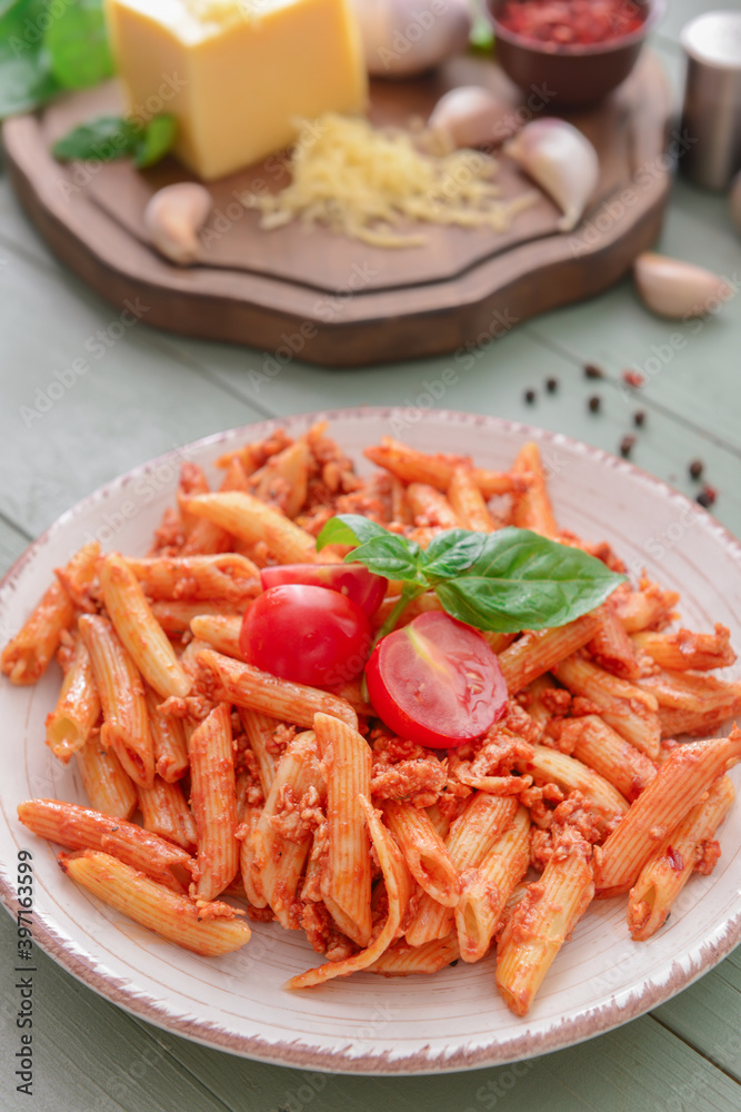 Plate of delicious penne pasta with tomato sauce on wooden background Plate of delicious penne pasta with tomato sauce on wooden background