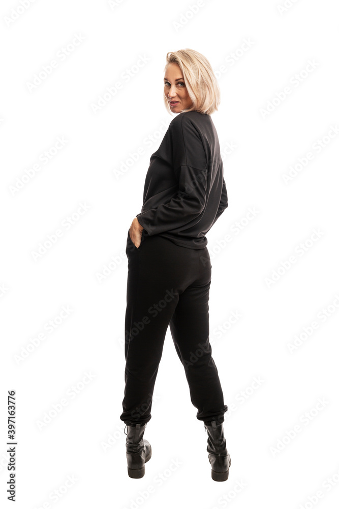 Young blonde woman in black casual suit and rough boots. Full height. Back view. Isolated on white background. Vertical. Young blonde woman in black casual suit and rough boots. Full height. Back view. Isolated on white background. Vertical.