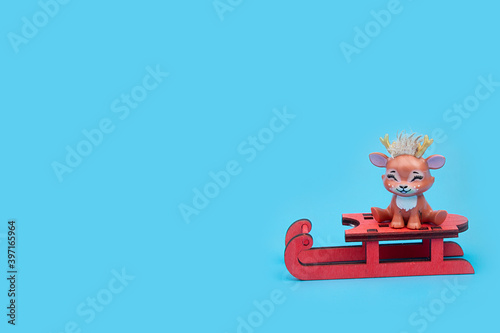Cute Christmas reindeer sitting on a sled. Concept of Christmas, happy New year. Postcard.