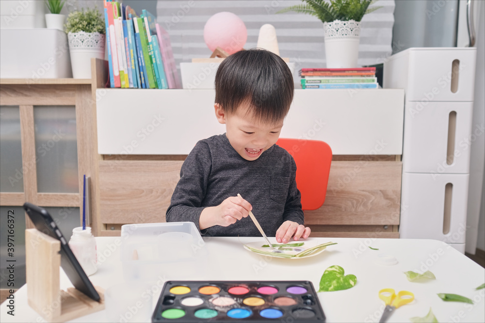 Cute happy smiling little Asian toddler boy enjoy using glue doing art project at home, Fun paper and glue crafts for toddlers Cute happy smiling little Asian toddler boy enjoy using glue doing art project at home, Fun paper and glue crafts for toddlers