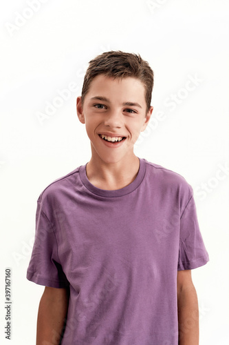 Close up portrait of happy teenaged disabled boy with cerebral palsy smiling at camera, posing isolated over white background