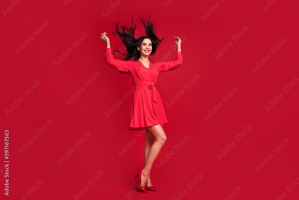 Full length body size view of adorable cheerful model posing having fun wind blow hairstyle isolated on vivid red color background