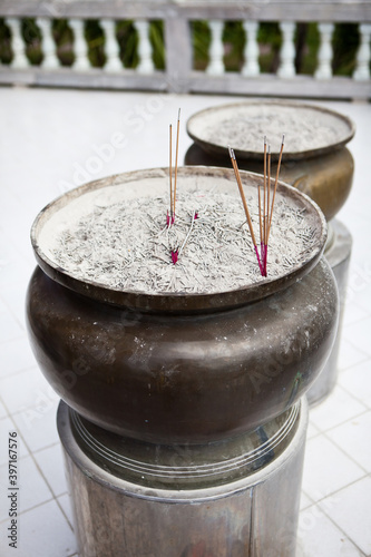 Incense sticks on joss stick pot are burning and smoke use for praying Buddha or Hindu gods to show respect.