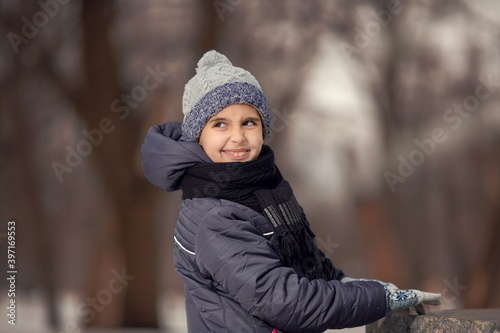 Winter portrait of a happy smile boy in hat. Christmas time. Snowdrift, cold. Happy new year. Winter holidays in the forest with snow