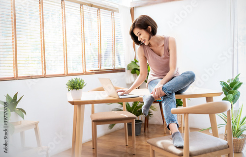 Portrait of young beautiful asian woman relax sit on desk use computer laptop. Smile happy asian girl online vlog conference at home. Freelance small business owner sme, work from home concept.