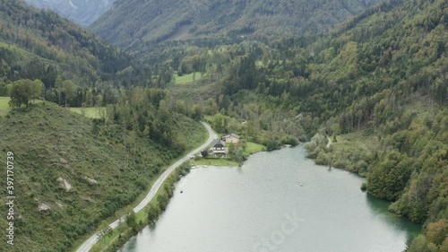 South shore of Freibach reservoir dam in Austria with the Stauseewirt Greek restaurant, Aerial dolly out reveal shot photo