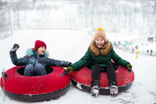 Vászonkép Children are loving tubing down a steep hill during a snowly winter