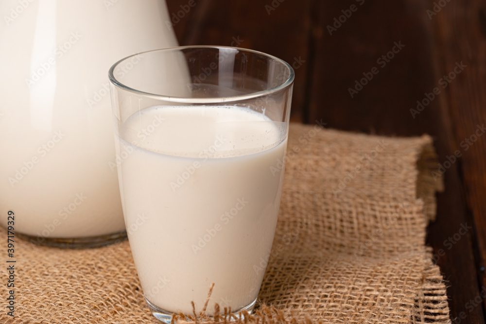 Glass pitcher of milk on old wooden table Glass pitcher of milk on old wooden table