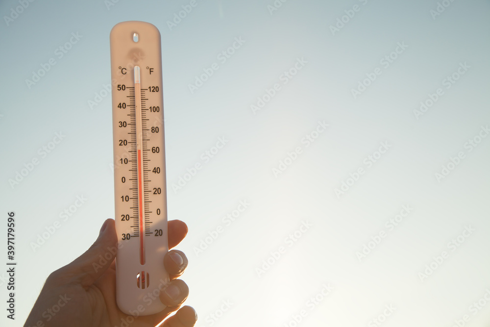 Hand holding thermometer on sky background. Hand holding thermometer on sky background.
