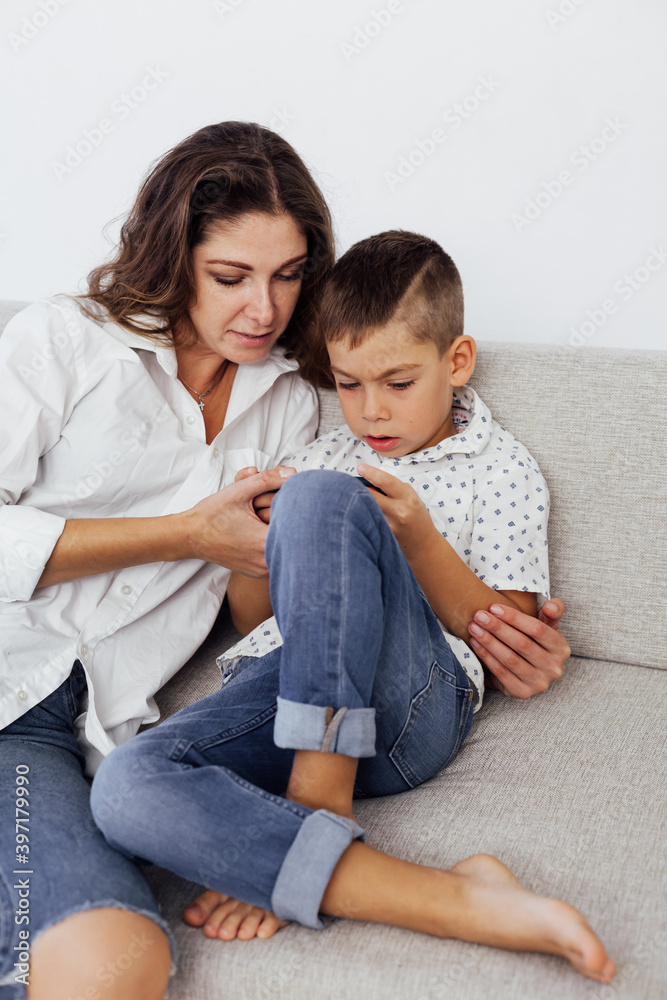 Mom and son play smartphone games on the couch
