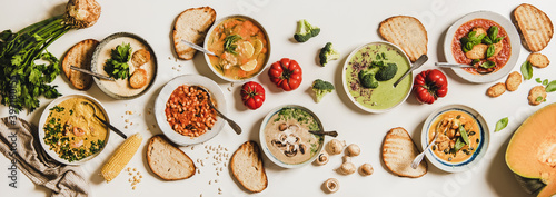 Valokuva Flat-lay of vegetarian creamy homemade soup in plates with bread slices over white plain table background, top view