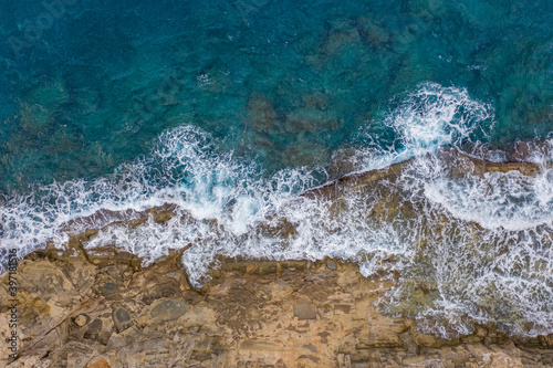 Aerial top view of sea waves hitting rocks in Rhodes island Greece