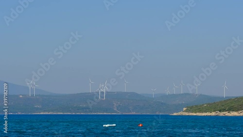 Sailing boat in the sea and windmills top of the hill on background. Two men training in little tiny sailing in the sea.