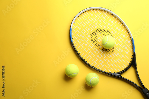 Tennis racket and balls on yellow background, flat lay. Space for text © New Africa