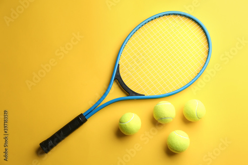 Tennis racket and balls on yellow background, flat lay. Sports equipment © New Africa