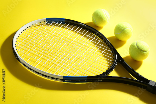 Tennis racket and balls on yellow background. Sports equipment © New Africa