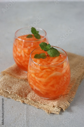 Es Blewah. Indonesian cold fruity drink of cantaloupe strips with cocopandan syrup serve in glass. Very popular during Ramadhan. Iftar meal. photo