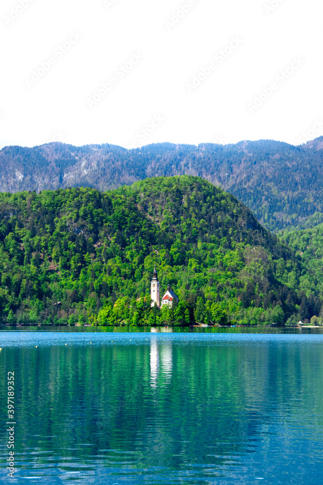 Beautiful and spectacular Julian Alps and Lake Bled and church on the island. Snow-capped mountain peaks in the background. Slovenia