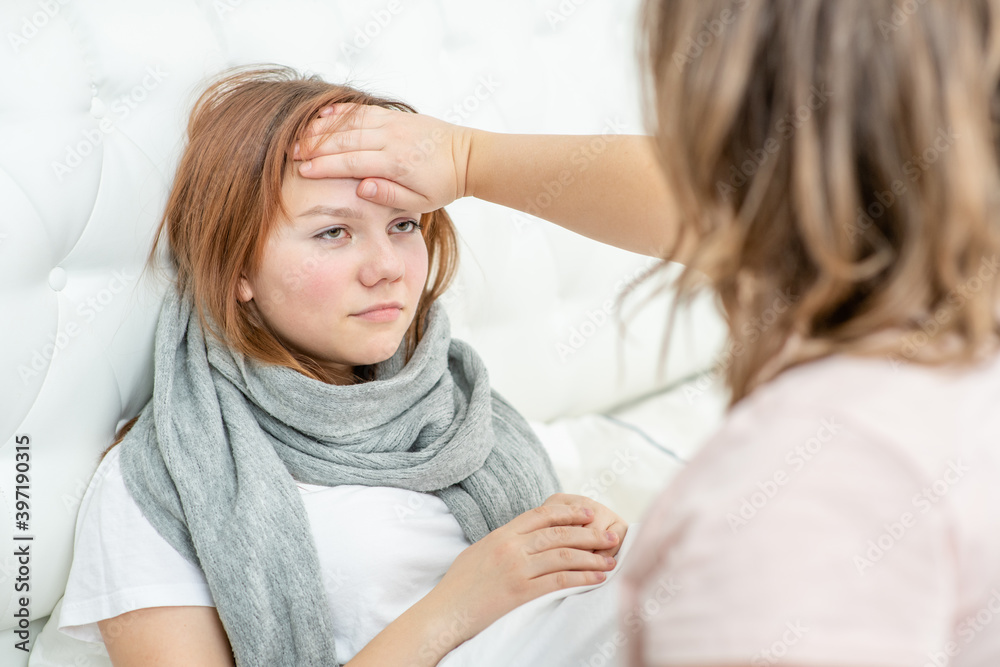 Mother touches the forehead of the girl, checking the temperature Mother touches the forehead of the girl, checking the temperature