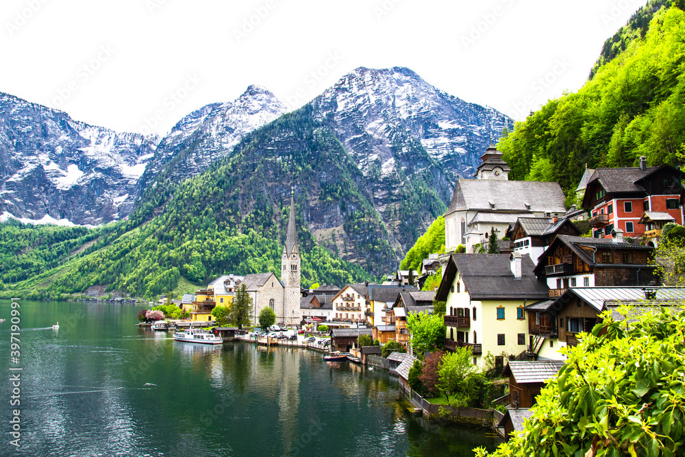 View of buildings and old church along the coastline. View of the mountains and monuments of the city. Hallstatt, Austria