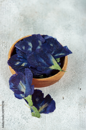 Bunga telang oshibana or Butterfly pea flowers (Clitoria ternatea) press flowers in basket on wooden blackground photo
